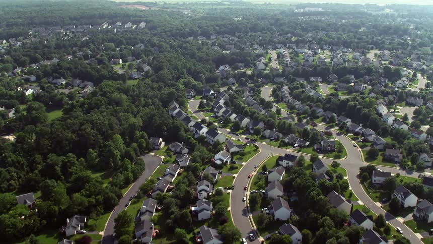 Aerial footage flying over homes row houses and a strip mall on Hastings Drive in Manassas Virginia during the daytime