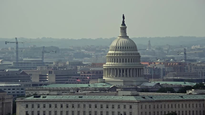 Aerial view of the iconic United States Capitol dome behind the James Madison Building in Washington DC on a hazy summer day