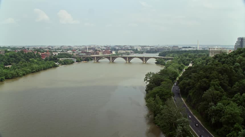 Aerial footage of Francis Scott Key Bridge spanning the Potomac River in Washington DC on a hazy day with light traffic