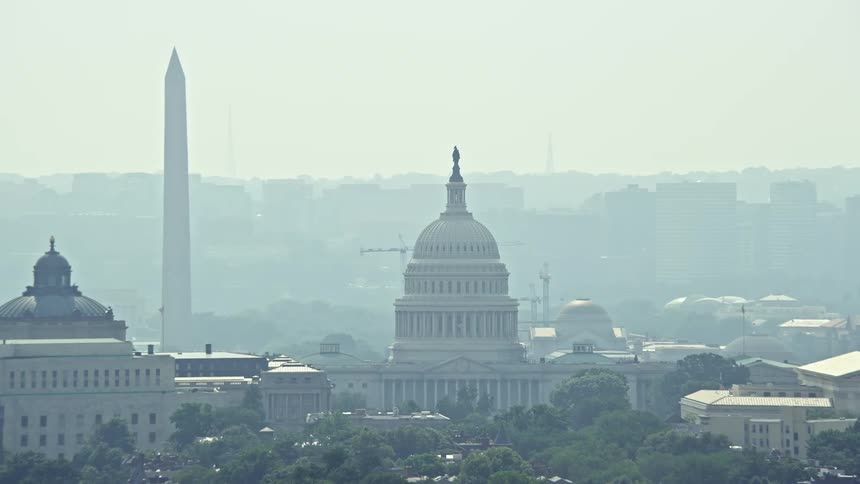 Aerial footage of the United States Capitol Supreme Court and the Washington Monument in Washington DC on a hazy day