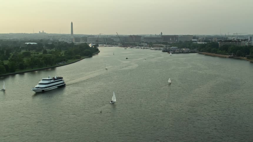 Approaching sailboats and ferry on Washington Channel near Washington Monument during sunset seen from a aerial perspective