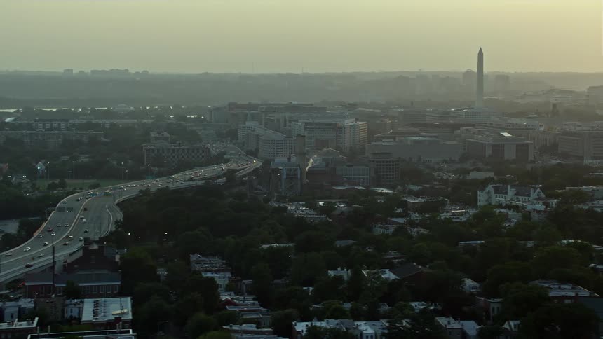 Aerial footage of Washington DCs Interstate 695 Capitol Power Plant and the Washington Monument during sunset