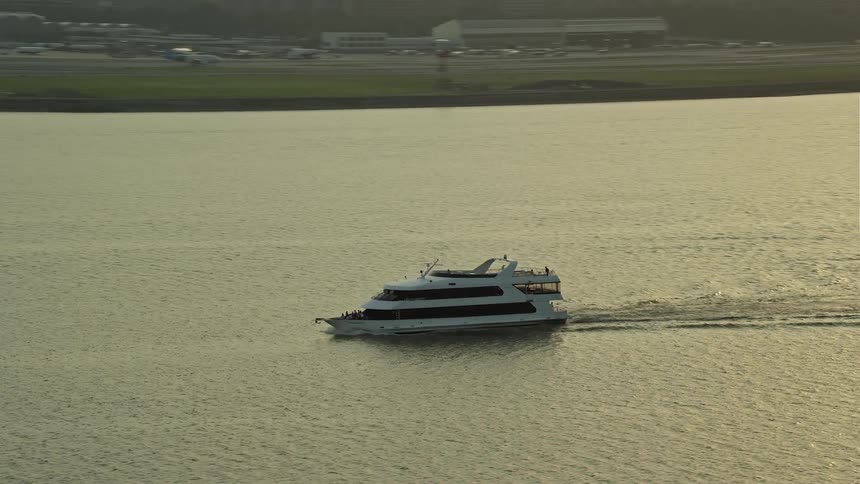 Aerial footage tracking a ferry on the Potomac River during sunset in Arlington Virginia