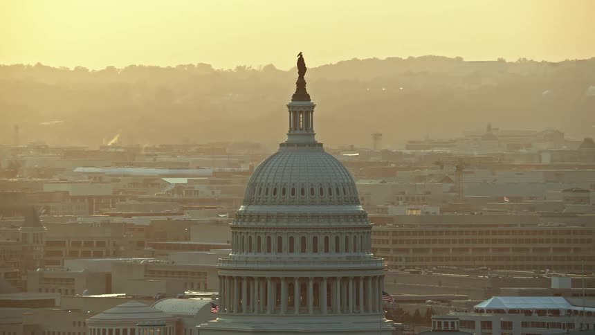 A stunning aerial view of the United States Capitol and Thomas Jefferson Building domes at sunset in Washington DC