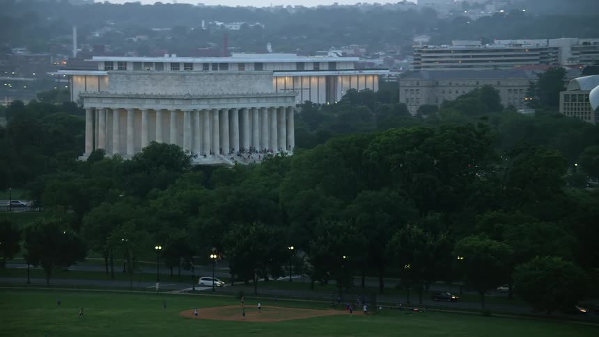 Aerial footage captures the Lincoln Memorial during twilight with a hazy yet revealing view of the famous landmark surrounded by trees