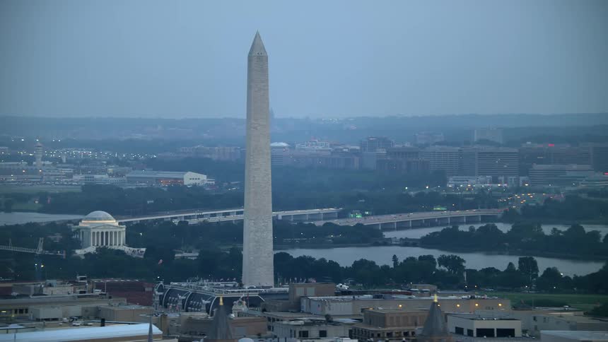 Stunning aerial footage captures the Washington Monument Jefferson Memorial and Reagan National Airport during twilight showcasing the historic landmarks and transportation hub of Washington DC