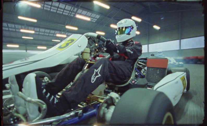 People race vehicles around an indoor track