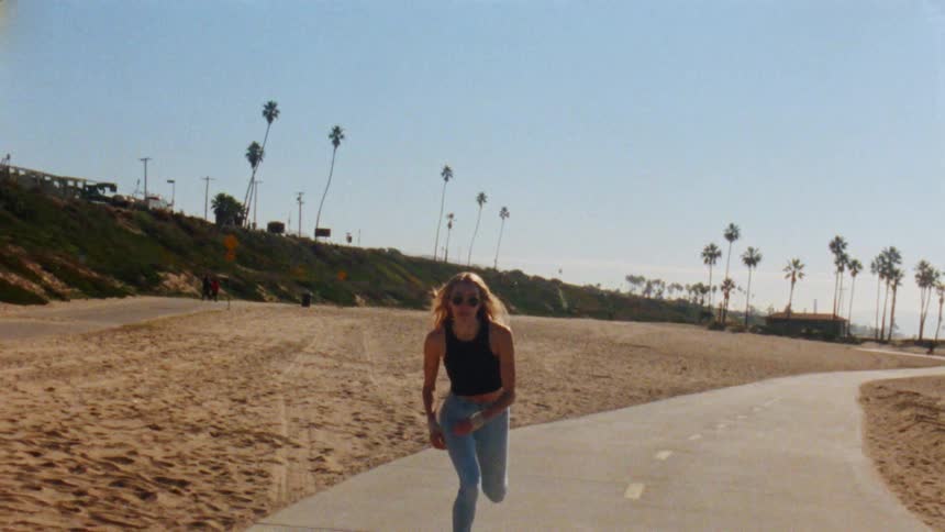 A woman is skate boarding outdoors during spring