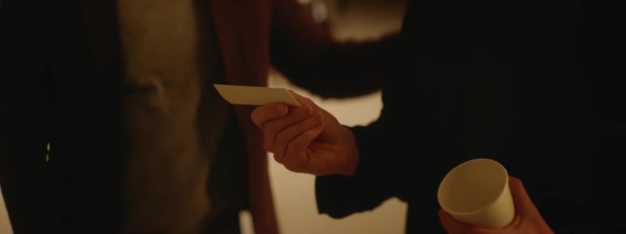 Man hands off business card to another man