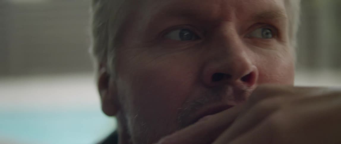 A man sits indoors while lost in thought