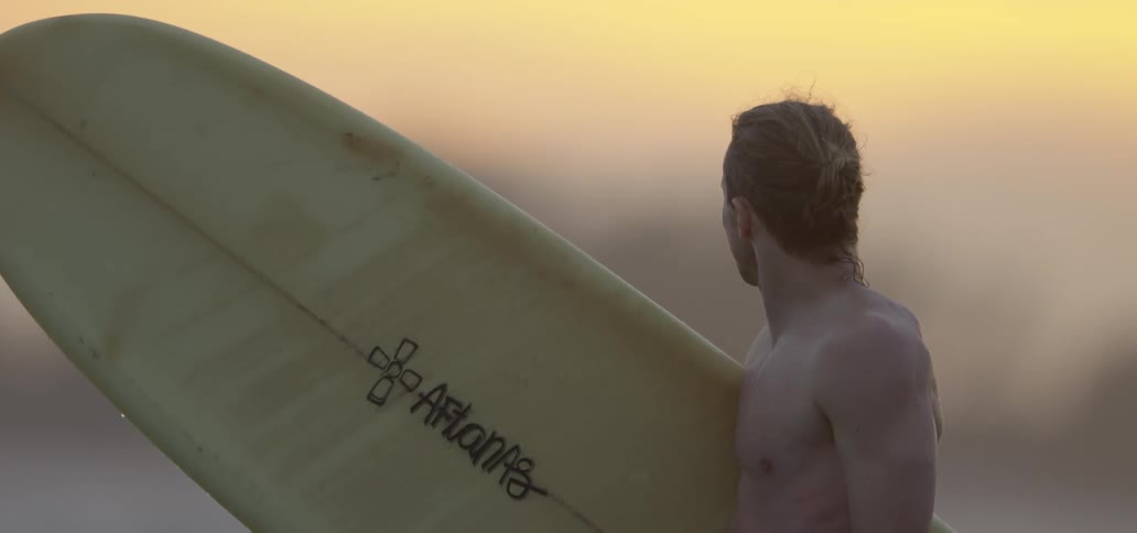 A man is holding a surfboard