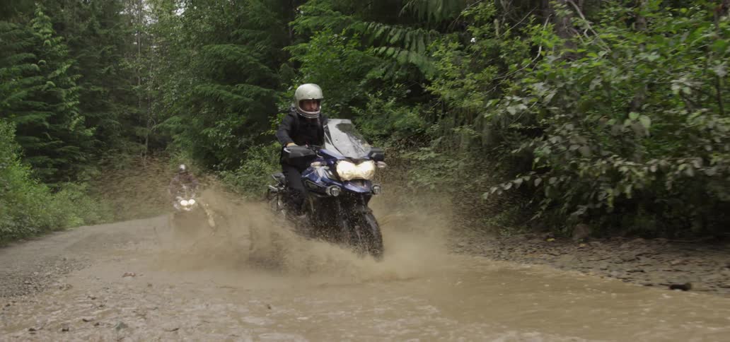 Two motorcycles race through the mud