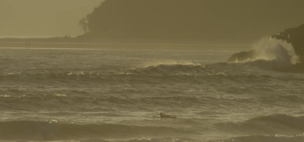 A man is surfing in some rough waves