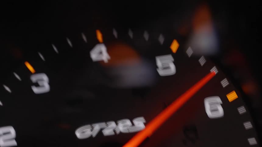 The needle of a gauge on the dashboard of a porsche gt2 rs is moving wildly