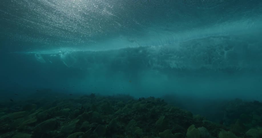 Waves rolling in the ocean from underwater with reef on the bottom