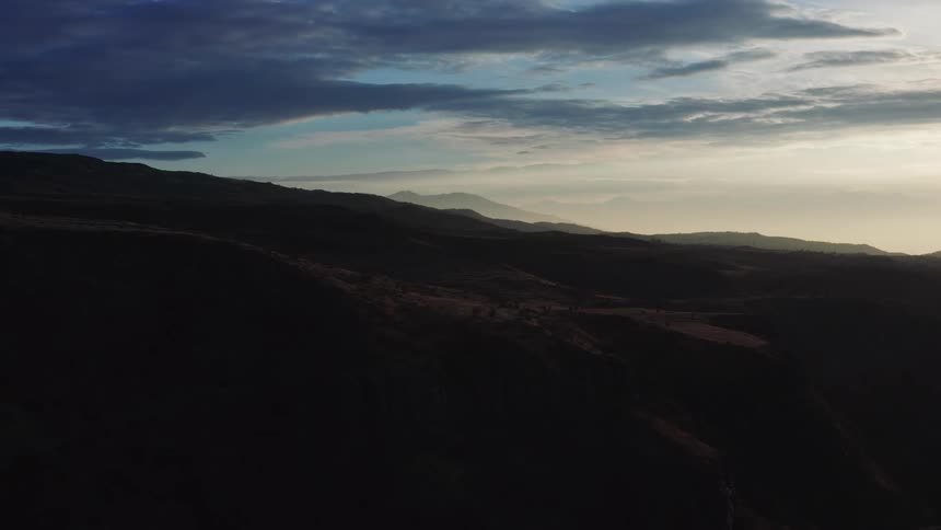 A silhouette landscape of mountains cascading in the distance