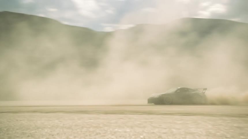 A black coupe sports car driving doing donuts in the desert