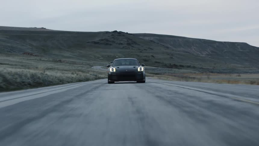 The car travels on the road in front of the mountain