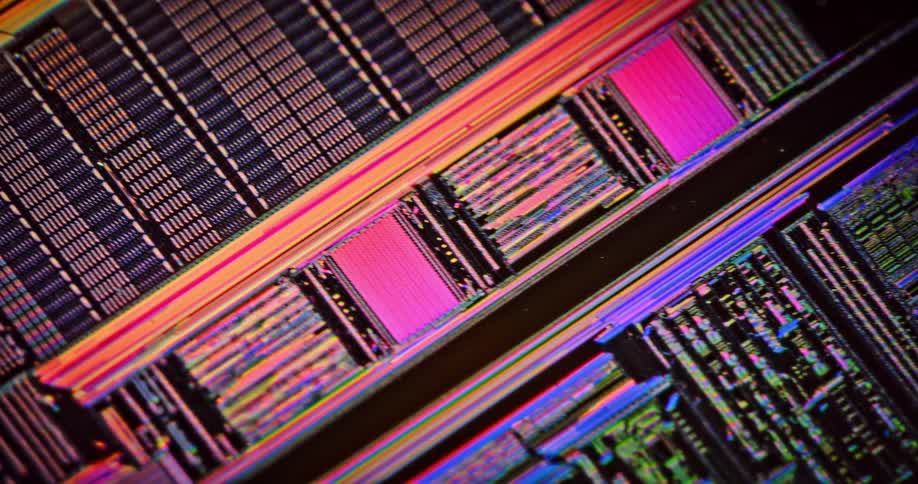 A circuit board shimmers and glows with color as light passes over it