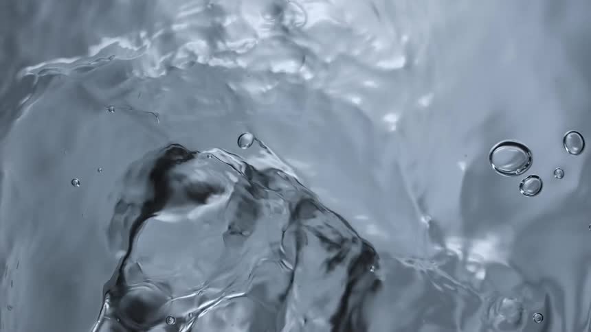 Bubbles in water are slowly moving as they rise to the surface