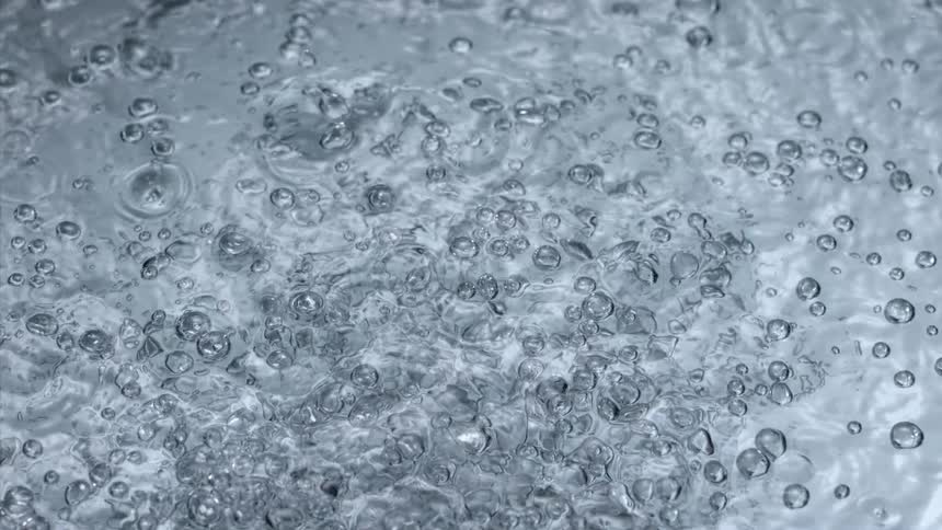 Bubbles rise to the surface of clear liquid