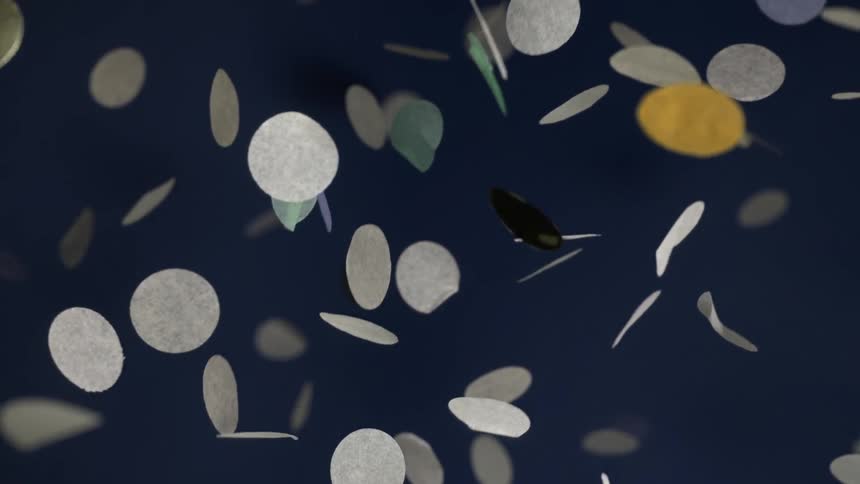 Circular confetti some metallic falls slowly through the air