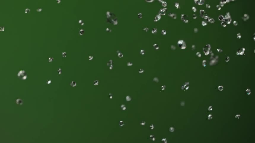 Light shines on diamonds flying in the air and glittering as they turn and spin