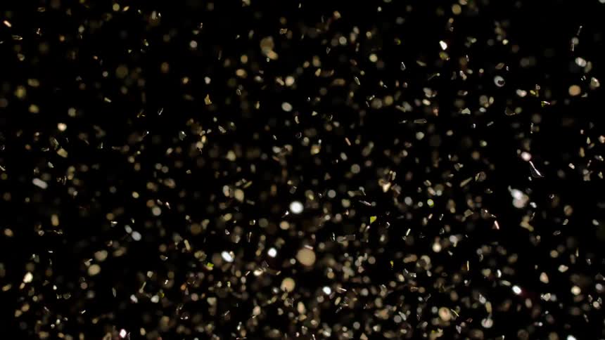 Golden and shiny confetti explosion with reflections