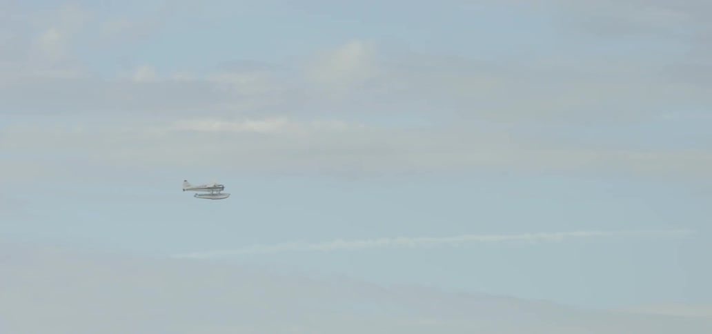 A plane is traveling along a cloudy sky