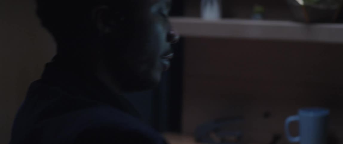 A male employee talking through a headset with a highlighter in hand at his desk