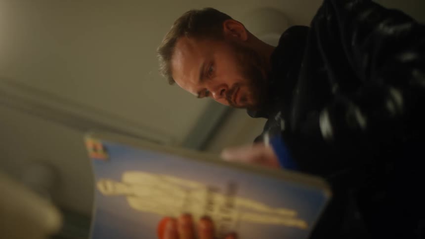 A man flips through a thick handbook