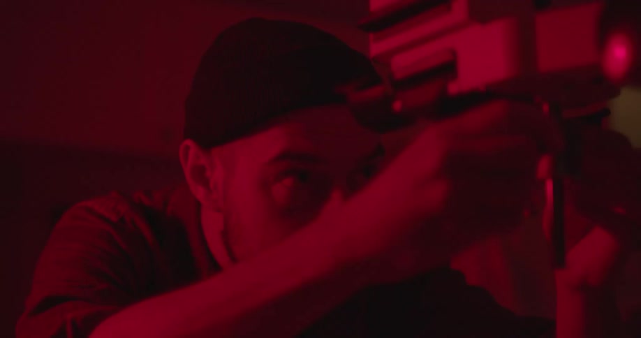 A camera man adjusts his equipment for something
