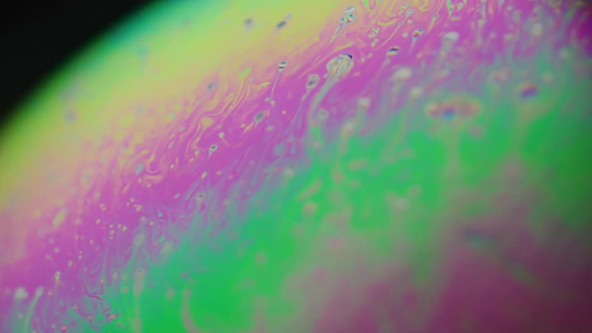 Drops and lines of color flow upward between layers creating streaks
