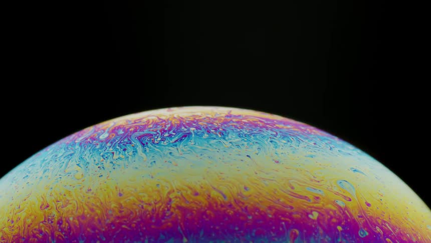 Fluorescent colors move across the surface of a yellow sphere and blends in an organic manner