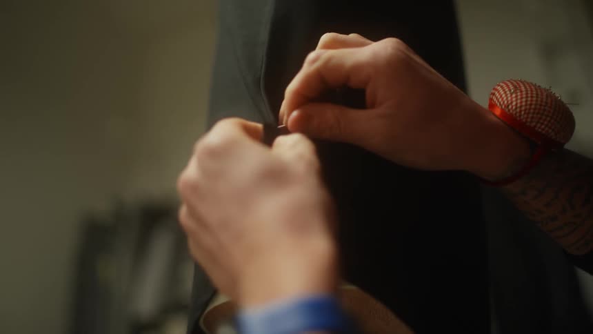 A fashion designer pins fabric on a dress form