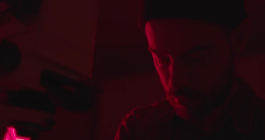 A male photographer developing photos in a darkroom