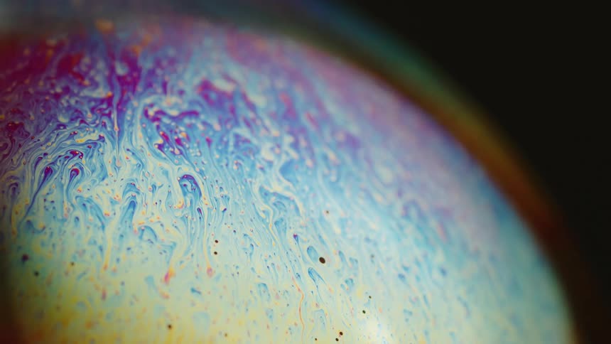 Colors move across the surface of a sphere as they drip and blend in an organic manner