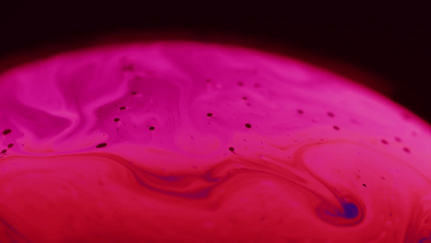 Red and purple fluid swirls in layers in sphere contrasting with dark background