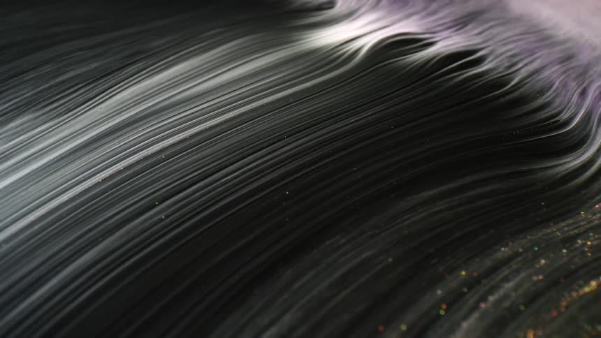 A thick black liquid flowing off camera