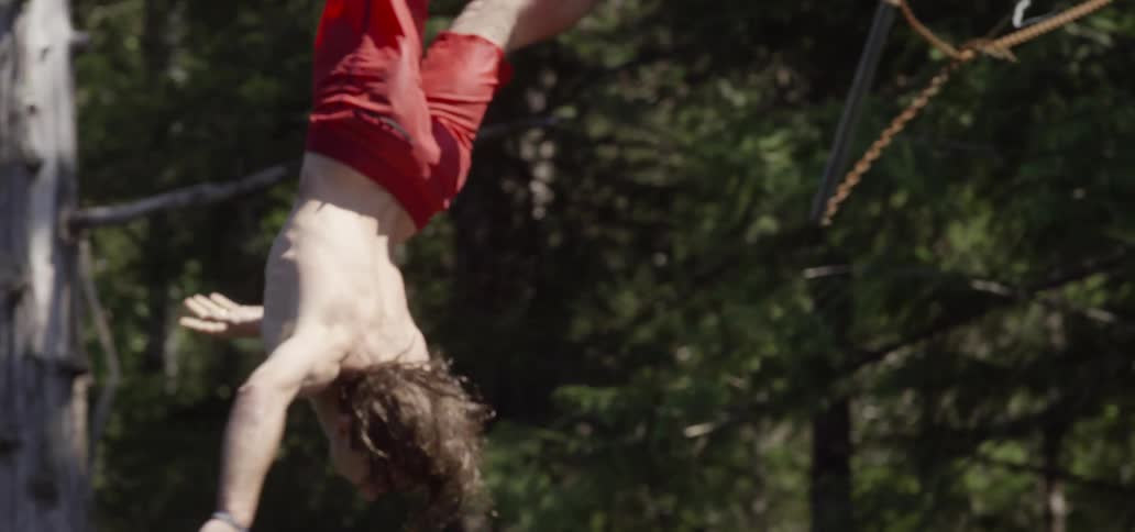 A man swings off a rope and flips while falling
