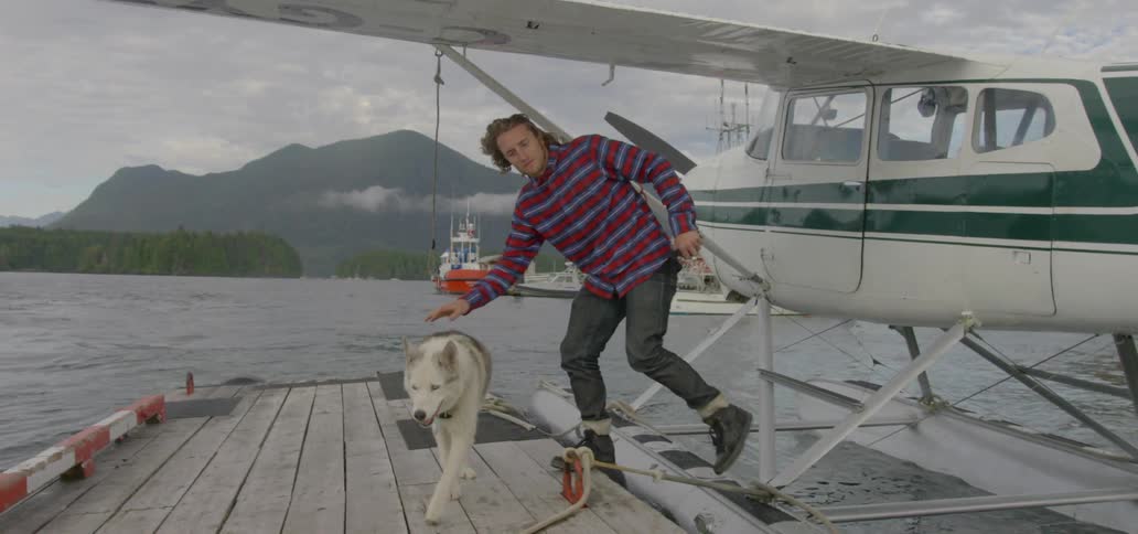 A man climbs off a plane with his dog