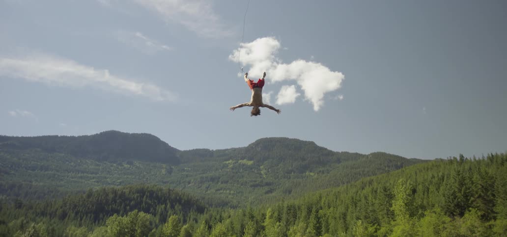 A man swings and falls into a lake