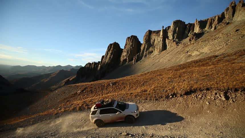 An suv travelling up a steep dirt road in the mountains