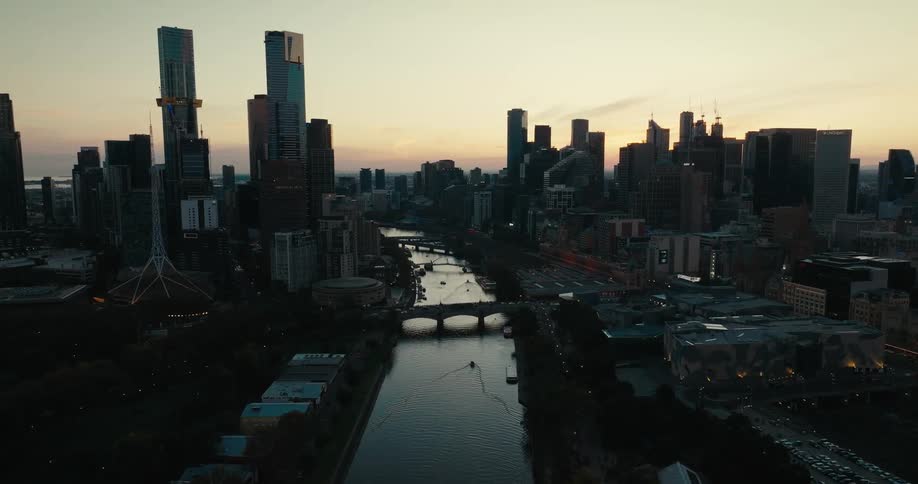 Aerial view of the skyline of a big city showing a river bridges and sky scrapers at sunset