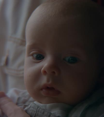 A baby sits on its parents lap