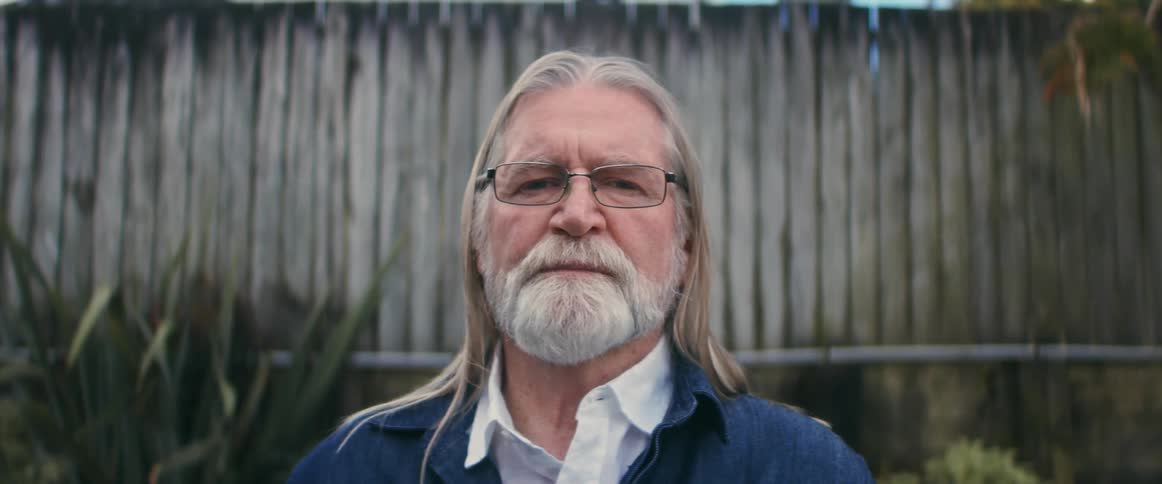 A man is posing outside