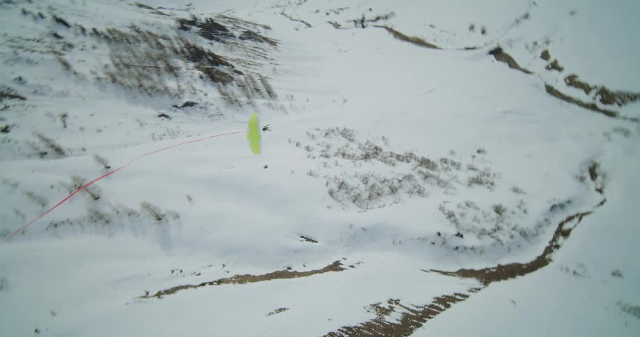 A person is paragliding over the mountains