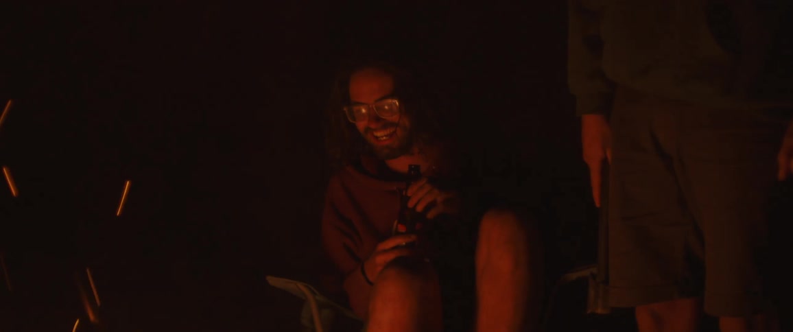 Friends talk and have beer at the campfire