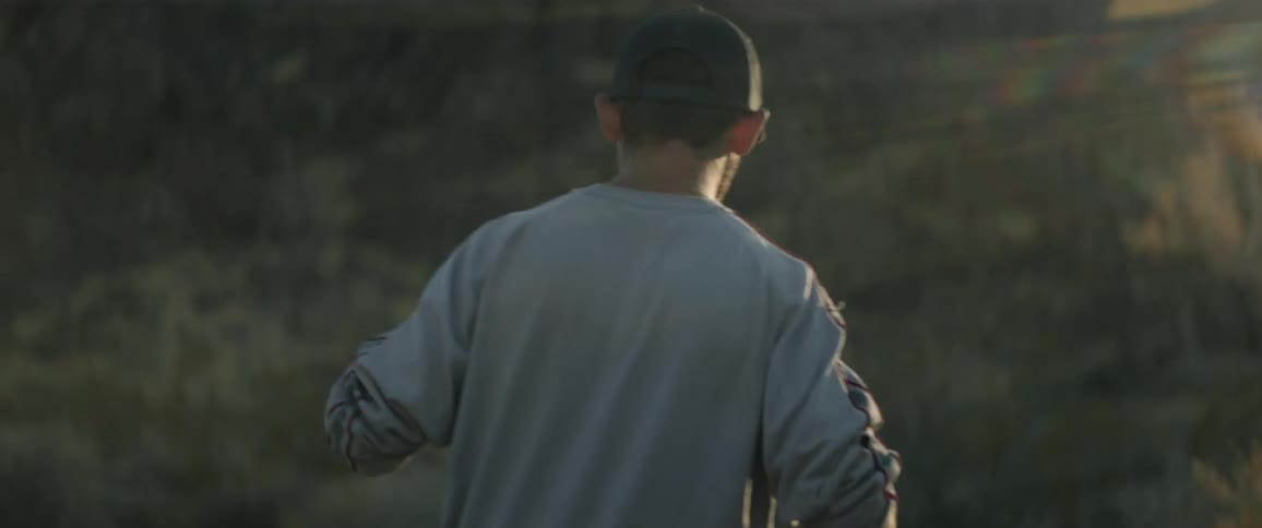 A young boy walks across a field
