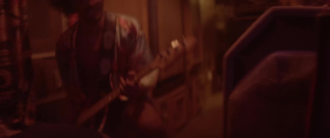 A man headbanging while playing an electric guitar